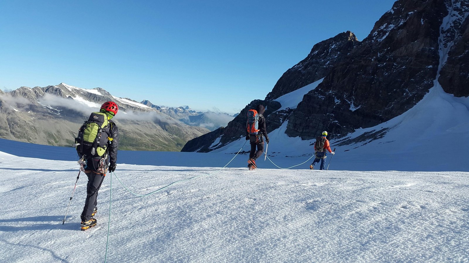 Adventure climbers on a snow-laden alpine trek, exemplifying teamwork in a breathtaking winter landscape.