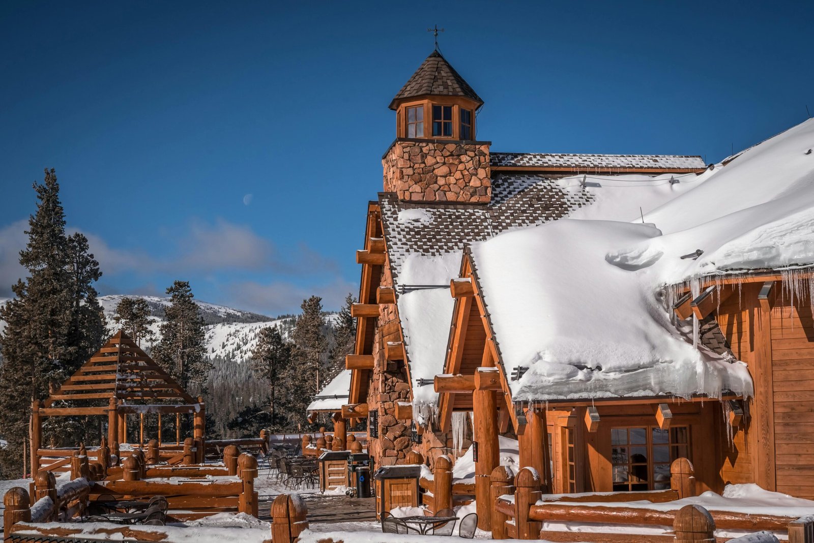 Rustic snow-covered lodge set against a stunning winter landscape.