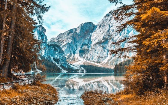 Stunning view of Lago di Braies reflecting snow-capped mountain peaks in Veneto, Italy.