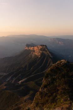 Captivating view of Mexico's rugged mountains at sunrise, shrouded in mist.
