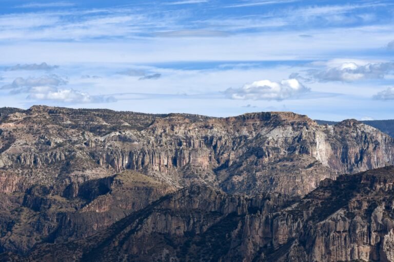 Breathtaking view of Copper Canyon in Chihuahua, Mexico with rugged rock formations under a clear blue sky.