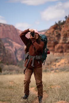 A woman hiker with a backpack captures the majestic Utah landscape with her camera.