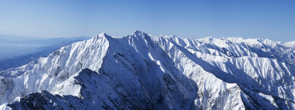 Explore the stunning beauty of snowy mountain peaks under a clear blue sky