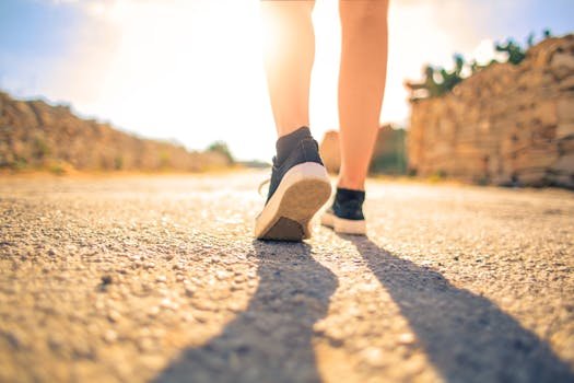 A woman walks down a sunlit path in summer, highlighting leisure and travel outdoors.