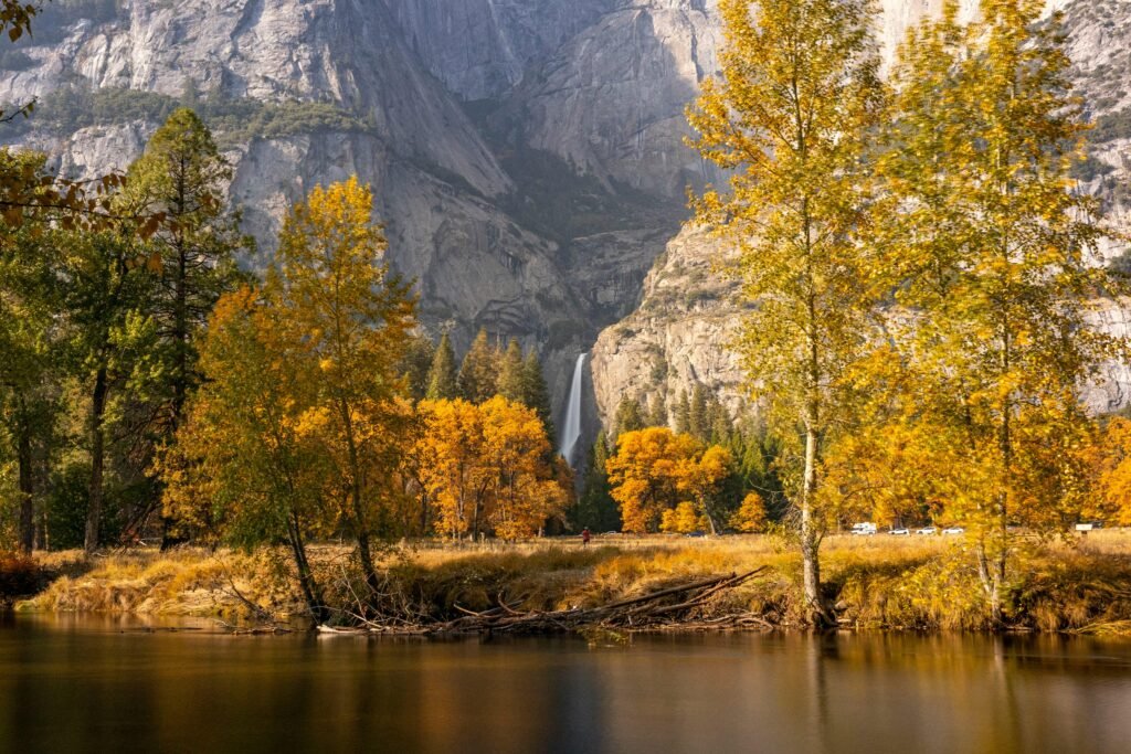 Stunning autumn landscape with waterfall in Yosemite, showcasing vibrant fall foliage and majestic cliffs.