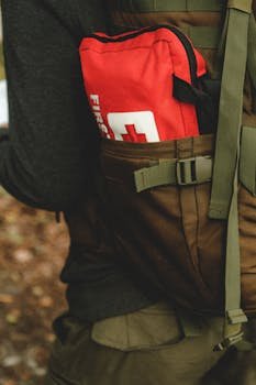 Close-up of a red first aid kit in a hiker's backpack, perfect for outdoor safety.